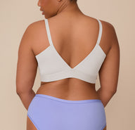 Back view of Zarria wearing the Bliss Triangle Bralette in Frost. The image shows the bralette’s deep V-back and front adjustable straps, emphasizing comfort and a sleek silhouette.
