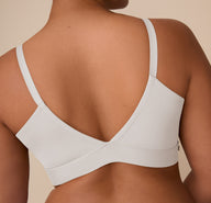Back view of Zarria wearing the Bliss Triangle Bralette in Frost. Her pose highlights the supportive V-back and smooth stretch fabric across the upper back and shoulders.