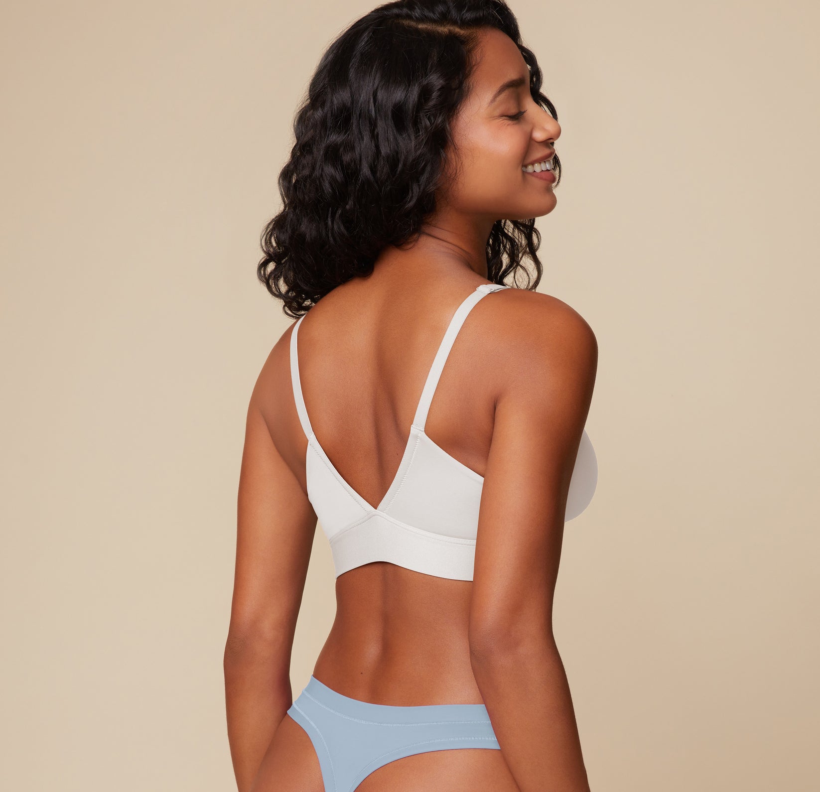 Three quarter angle of Ally wearing the Bliss Triangle Bralette in Frost. Her pose showcases the deep V-back and soft contouring designed for natural shaping and support.