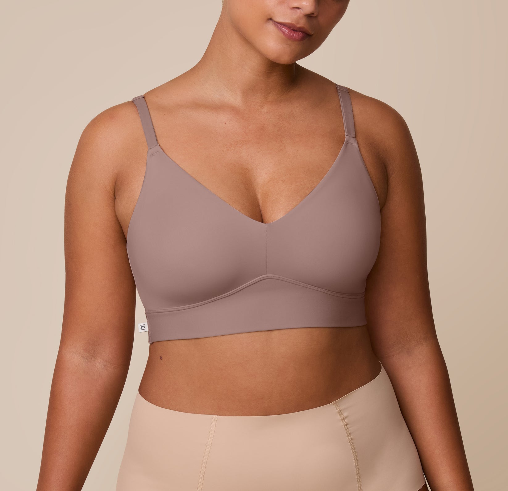 India wears the Bliss Triangle Bralette in Mauve, a soft dusty rose tone. The bralette features a deep V neckline and supportive underband, blending comfort with everyday lift. sizing: India wears size Large