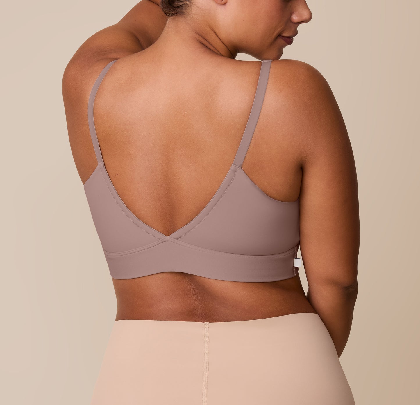 Back view of India in the Bliss Triangle Bralette in Mauve, showcasing the deep V-back and smooth, wide straps designed for gentle, all-day wear.