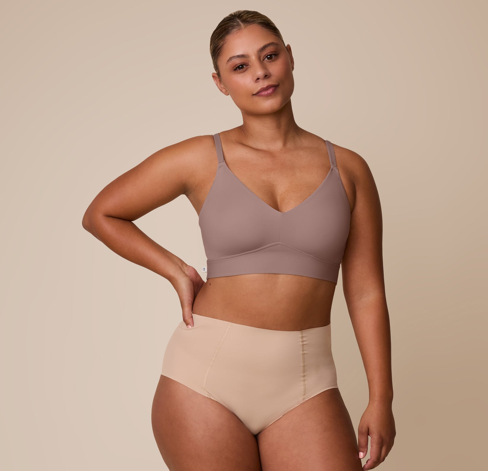 Full-body shot of India wearing the Bliss Triangle Bralette in Mauve paired with the No-Show Highwaist Brief in Beige. The image highlights the bralette’s flattering lines and modern silhouette.
