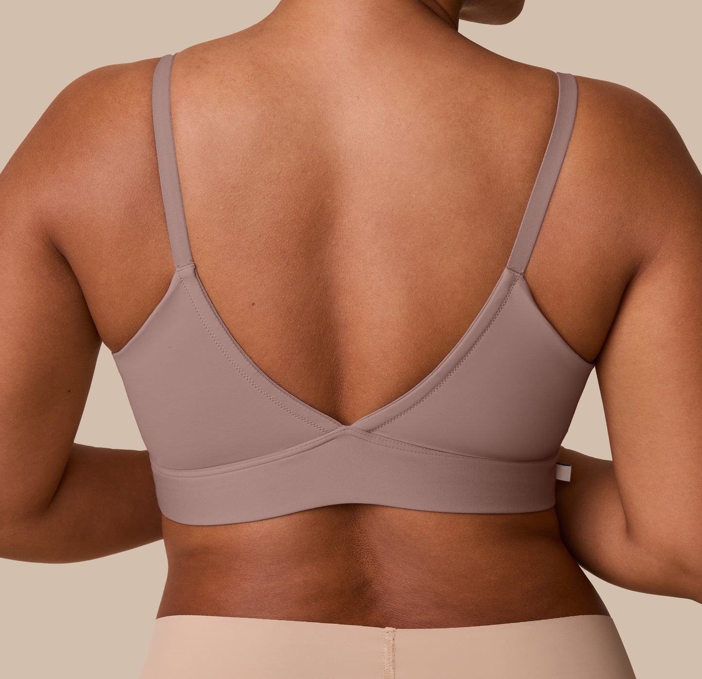Detailed back view of the Bliss Triangle Bralette in Mauve, emphasizing the bralette’s clean finish and flattering V-back on India.