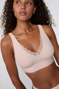 Close-up on a white studio backdrop of the Bliss Lace Bralette in Ember Rose, focusing on the lace-trimmed V-neckline, soft fabric texture, and wide shoulder straps.