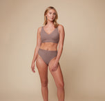 Model Megan wearing the Bliss Lace Bralette in Mauve paired with the Bliss Highwaist Lace Thong in Mauve. She stands facing forward, showcasing the bralette’s supportive fit and the thong’s high-waisted, flattering design.