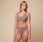 Megan posing in the Bliss Lace Bralette and Bliss Highwaist Lace Thong in Mauve. The front-facing image highlights the soft, comfortable design of both the bralette and the thong.