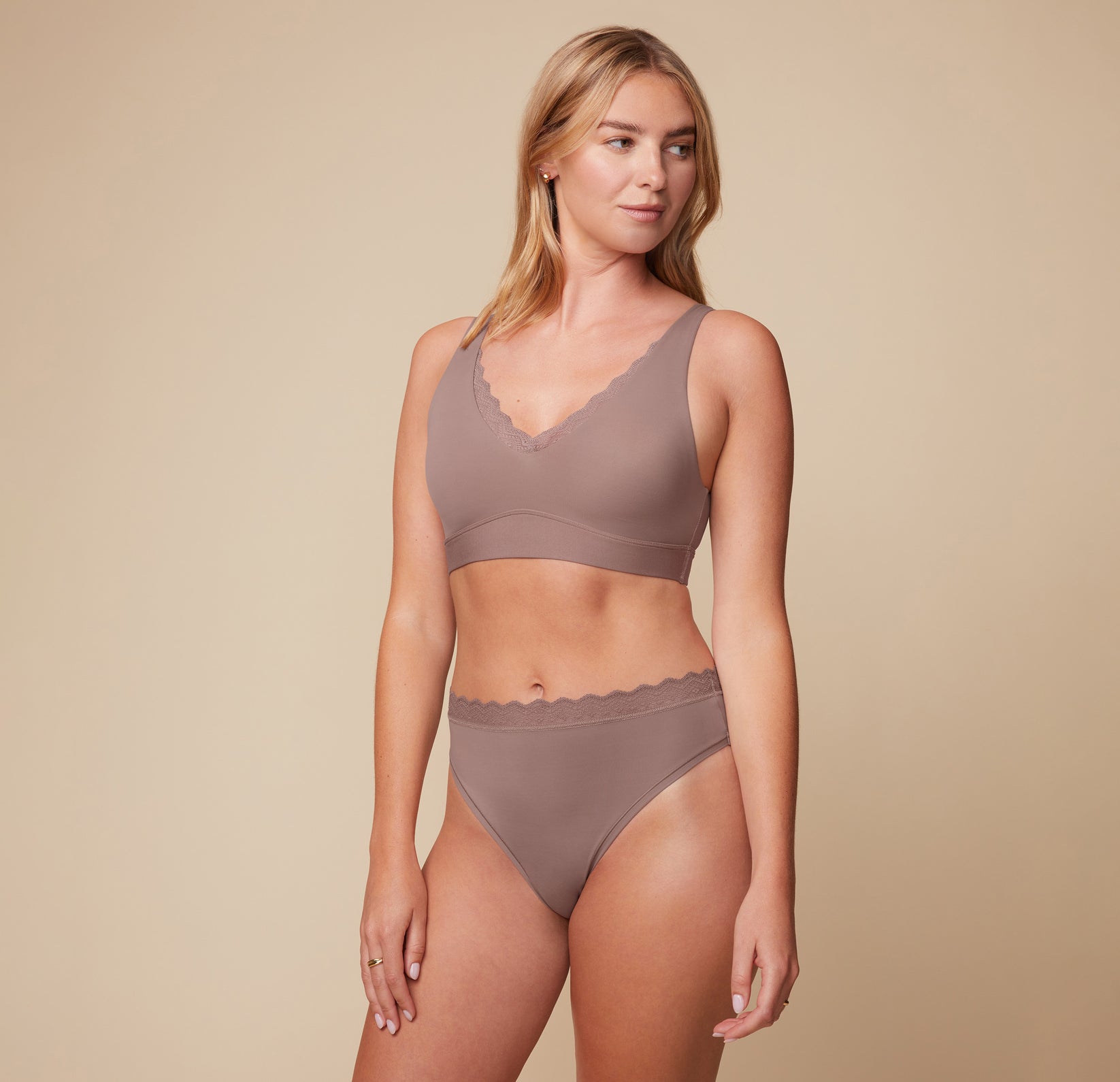 Megan posing in the Bliss Lace Bralette and Bliss Highwaist Lace Thong in Mauve. The front-facing image highlights the soft, comfortable design of both the bralette and the thong.