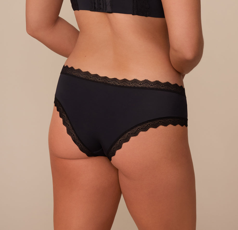 Back view of Sonnie in the Bliss Lace Cheeky Brief in Black. The image showcases the cheeky rear cut with soft lace edges designed to lay flat without digging.