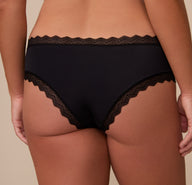 Close-up back angle of Sonnie wearing the Bliss Lace Cheeky Brief in Black. The image highlights the minimal coverage and stretch lace trim designed for a barely-there feel.