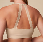 Close-up of the back view of the Bliss Lace Halterneck Bralette in Beige. The image focuses on the intricate lace halterneck strap, offering both style and support. sizing: Megan wears size Medium