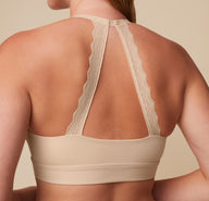 Close-up of the back view of the Bliss Lace Halterneck Bralette in Beige. The image focuses on the intricate lace halterneck strap, offering both style and support. sizing: Megan wears size Medium