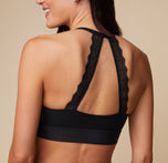 Close-up back view of Anna wearing the Bliss Lace Halterneck Bralette in Black. The image highlights the detailed lace halterneck straps, providing a stylish and supportive look. sizing: Anna wears size Small