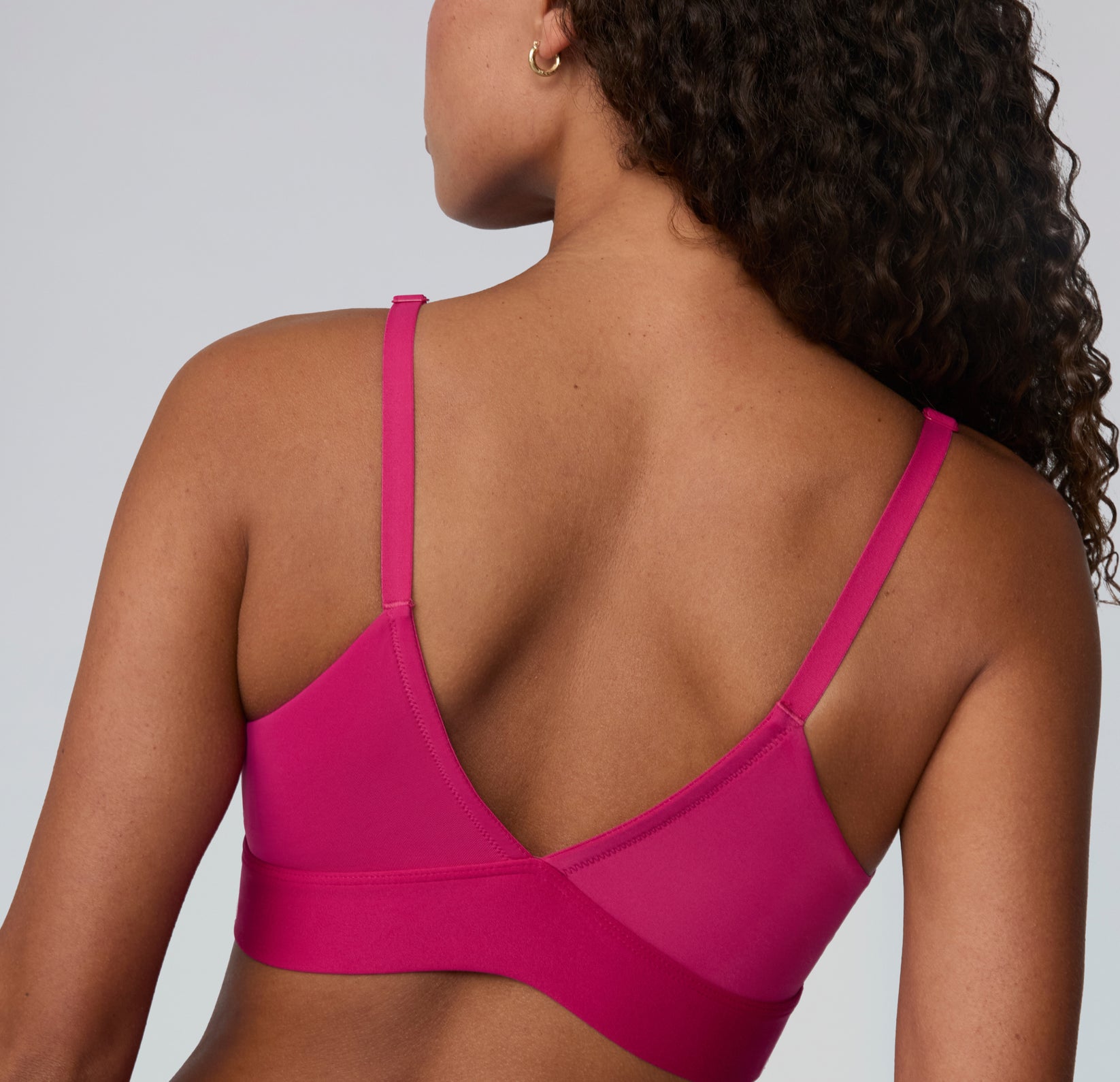 Back view on a white studio backdrop of the Bliss Triangle Bralette in Winterberry, highlighting the V-shaped back, adjustable straps, and smooth supportive band.