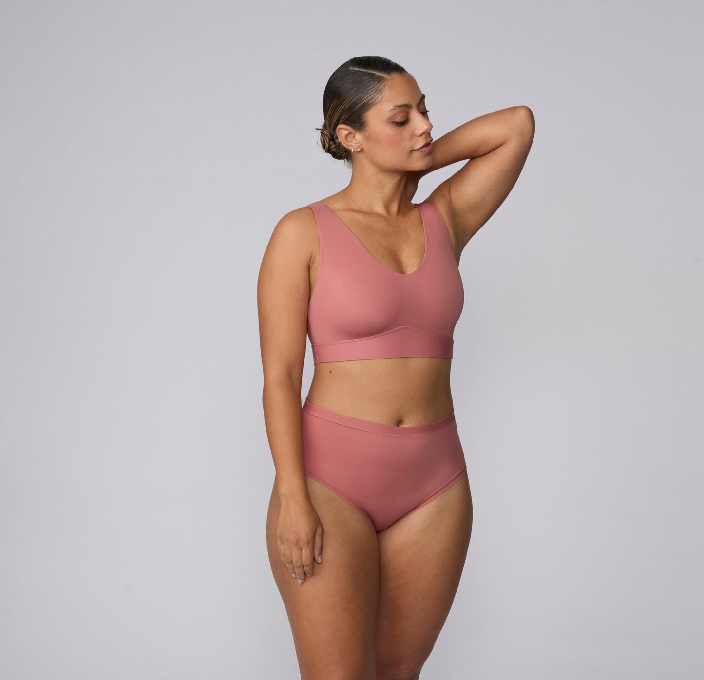 On a light gray studio backdrop, India wears the Bliss Highwaist in Cinnamon with a matching Bliss bralette. Shown in a full-body view, the high-waisted underwear features a smooth waistband, full coverage, and soft microfiber fabric designed for comfortable, everyday wear. sizing: India wears size Large