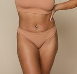 Close-up front view of Jade wearing the Cloud Cotton Bikini in Dune. The mid-rise fit and soft stretch waistband offer light coverage and everyday comfort. sizing: Jade wears size Small