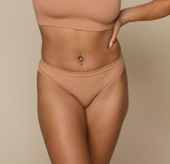 Close-up front view of Jade wearing the Cloud Cotton Bikini in Dune. The mid-rise fit and soft stretch waistband offer light coverage and everyday comfort. sizing: Jade wears size Small