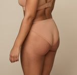Back and side view of Jade in the Cloud Cotton Bikini in Dune. The moderate rear coverage and gentle leg openings highlight the bikini’s smooth, flexible design.