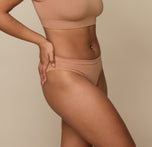 Side angle of Jade in the Cloud Cotton Bikini in Dune. The flat seams and soft, breathable cotton-modal fabric ensure a barely-there feel.