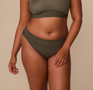 Zarria wearing the Cloud Cotton Bikini in Olive, shown from the front with mid-rise waistband and moderate coverage. sizing: Zarria wears size XL