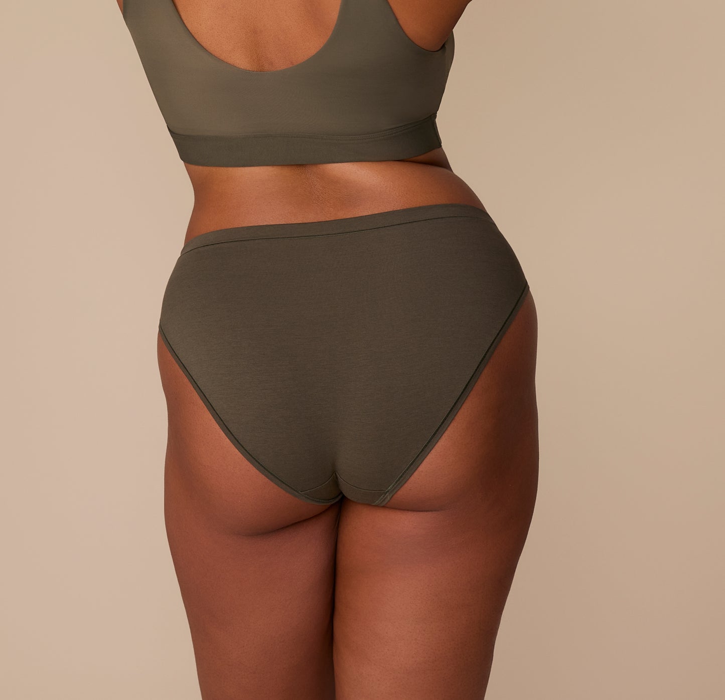 Back view of Zarria in the Cloud Cotton Bikini in Olive, highlighting the smooth waistband and full seat coverage.