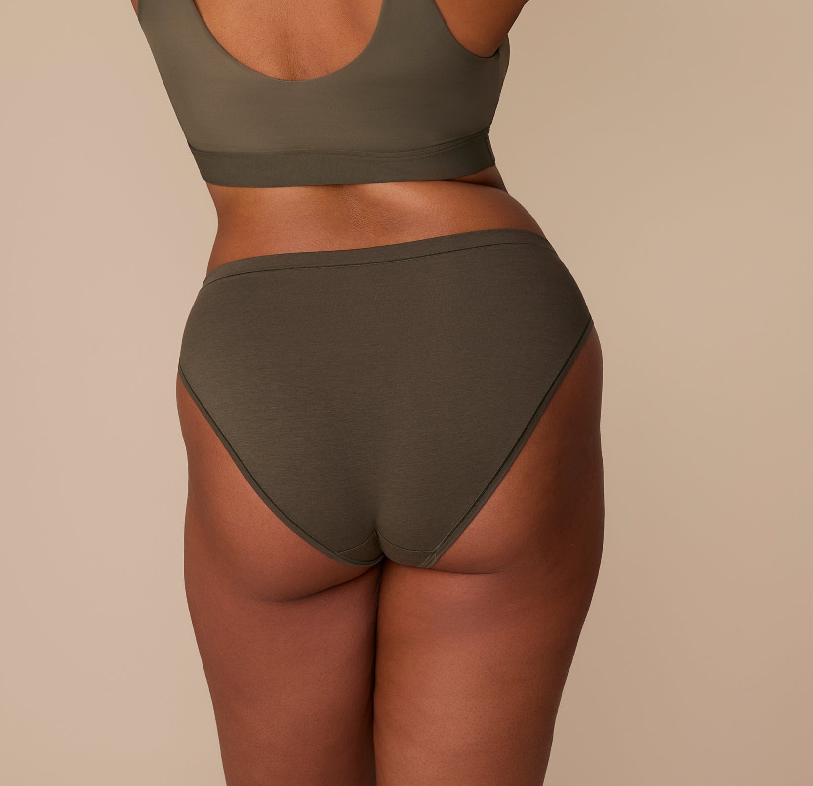 Back view of Zarria in the Cloud Cotton Bikini in Olive, highlighting the smooth waistband and full seat coverage.