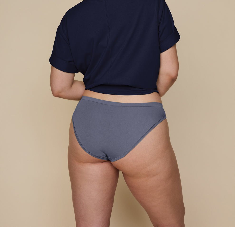 Back angle shot of Summerlyn wearing the Cloud Cotton Bikini in Slate. The medium coverage, comfortable fit, and soft cotton fabric are emphasized. 