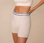 Three quarter angle of Freya modeling the Cloud Cotton Retro Boxer Brief in Quartz. The smooth, stretchy material hugs her body while the striped waistband sits comfortably at the waist.