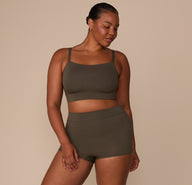Zarria wearing the Cloud Cotton Highwaist Boyshort in Olive with the Cloud Cotton Thin Strap Bralette, standing in a relaxed pose to show the full set.