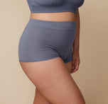 Side view of Bianca wearing the Cloud Cotton Highwaist Boyshort in Slate. Her body is slightly angled, showing the fit of the boyshort. sizing: Bianca wears size XL