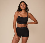 Full body shot of Victoria modeling the Cloud Cotton Highwaist Boyshort and matching Cloud Cotton Thin Strap Bralette in Black. She poses confidently with one hand on her hip, showcasing the full set’s casual, comfort-first appeal.