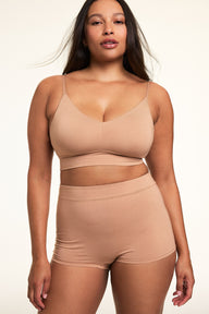 In a softly lit studio, Alana wears the Cloud Cotton Thin Strap Bralette and Cloud Cotton Highwaist Boyshort in Dune. The bralette features a square neckline, thin adjustable straps, and soft cotton modal fabric, paired with a high-waisted boyshort designed for full coverage and everyday comfort. sizing: Alana wears a size Large