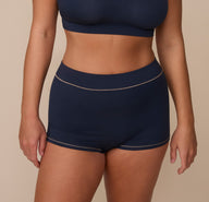 Front close-up of Sonnie wearing the Cloud Cotton Highwaist Boyshort in Midnight. The image highlights the boyshort’s high-rise fit and soft, full-coverage front panel with contrast stitching. sizing: Sonnie wears size Large
