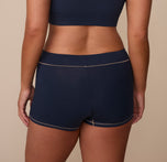 Rear view of Sonnie in the Cloud Cotton Highwaist Boyshort in Midnight. The photo showcases the wide waistband and mid-to-full back coverage for all-day comfort.