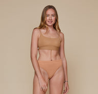 Front, full body view of Erin wearing the Bliss Scoop Bralette in the color Tan and the Cloud Cotton French Cut Brief in the color Dune.