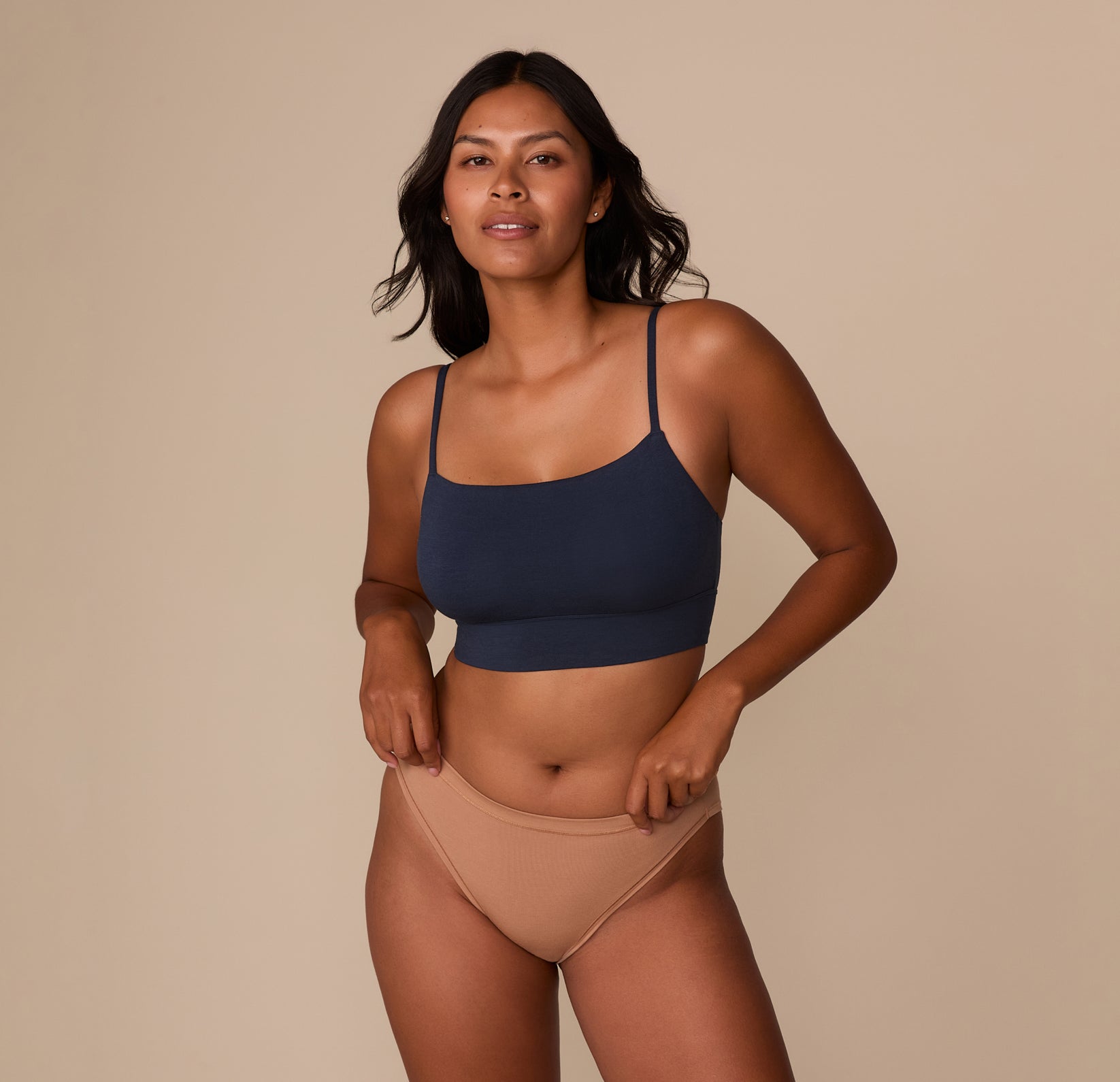 Victoria standing front-facing in the Cloud Cotton French Cut Brief in Dune, paired with the Cloud Cotton Thin Strap Bralette in Midnight. The image emphasizes the coordinated look and casual comfort of the set.