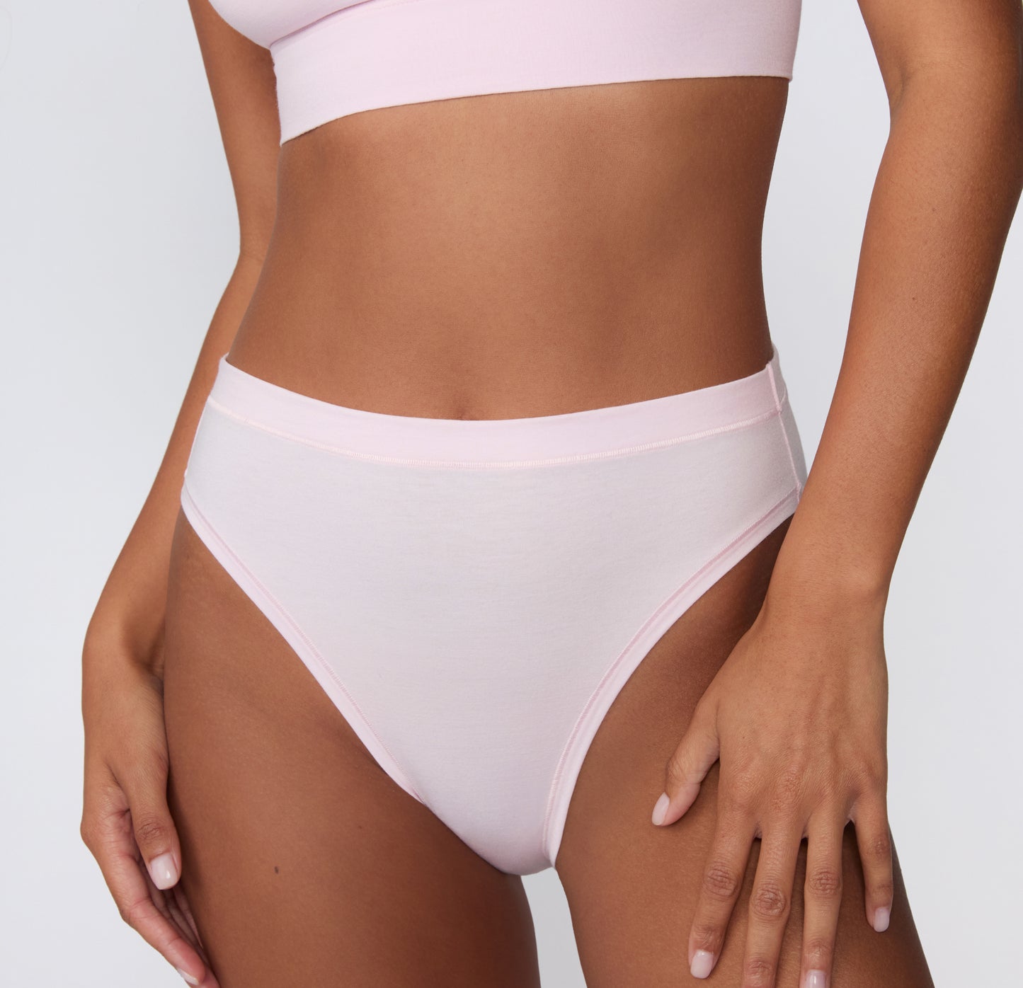 On a clean studio backdrop, a front close-up shows a model wearing the Cloud Cotton French Cut Brief in Primrose, highlighting the soft cotton modal fabric and smooth waistband. sizing: Courtney wears size Small