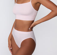 On a clean studio backdrop, a side mid-body view shows a model wearing the Cloud Cotton French Cut Brief in Primrose, highlighting the French-cut leg opening and smooth cotton modal fabric.