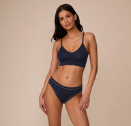 Full-body image of Marcela wearing the matching Cloud Cotton Triangle Bralette and French Cut Brief in Midnight. Her relaxed pose shows the high-rise fit and full front coverage of the set.