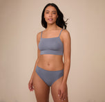 Full body image of Nemesis wearing the Cloud Cotton French Cut Brief and matching Cloud Cotton Thin Strap Bralette in Slate. She stands with a relaxed expression, presenting the coordinated, comfort-forward set.