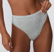 On a white studio backdrop, a close-up shows the Cloud Cotton Highwaist Thong in Heather Grey, highlighting the high-rise waistband, smooth cotton modal fabric, and clean stitched edges.