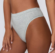 On a white studio backdrop, a close-up front angle of the Cloud Cotton Highwaist Thong in Heather Grey shows the soft cotton modal fabric and high-rise waistband.