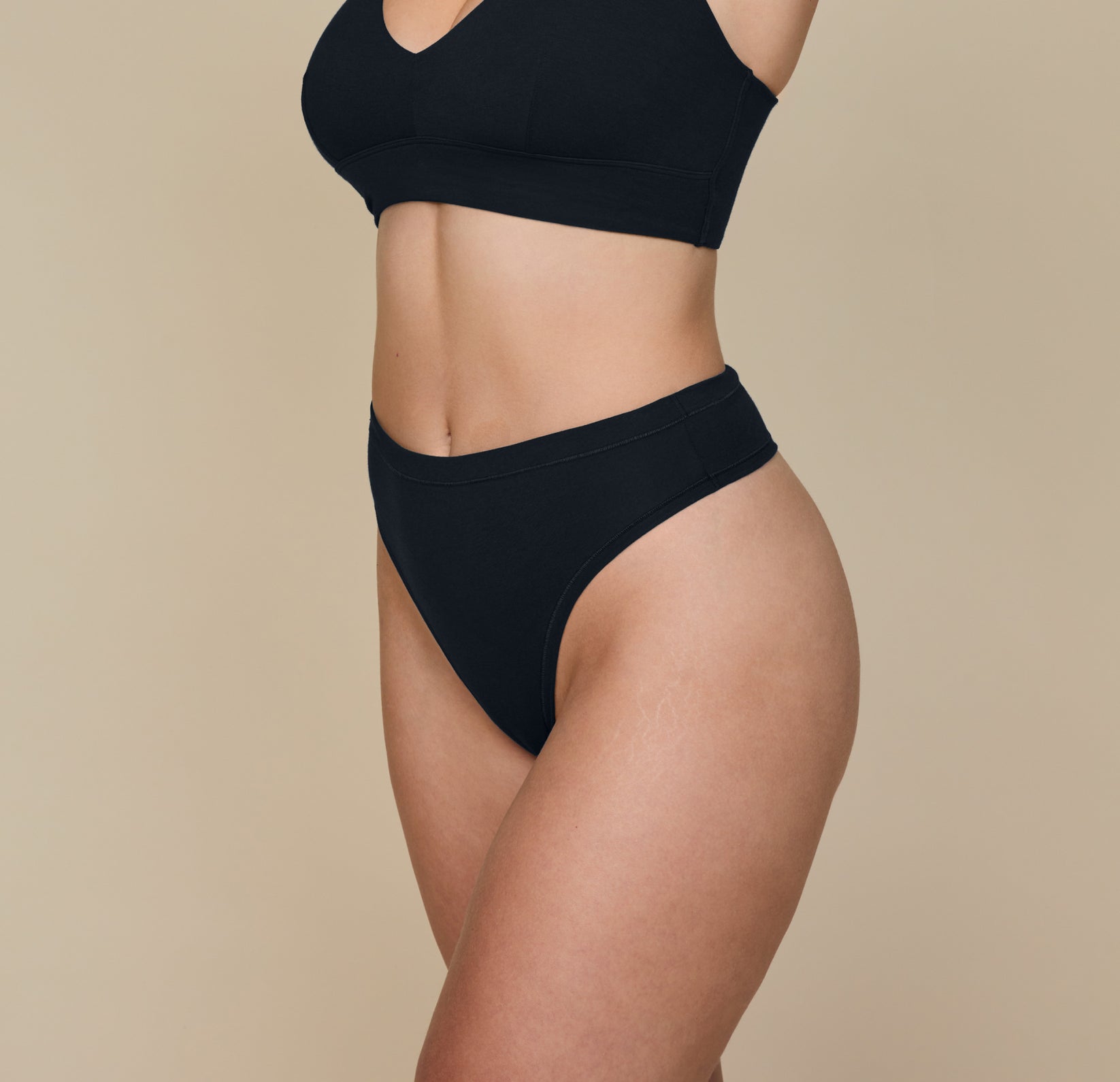 Side angle of Summerlyn in the Cloud Cotton Highwaist Thong in Black. The silhouette shows the contoured waistband and soft, breathable cotton-modal fabric.