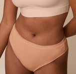 Close-up of the waistband and front panel of the Cloud Cotton Highwaist Thong in Dune, worn by Victoria. The detail highlights the soft, breathable fabric and clean finish at the edges.