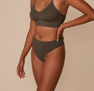 Side view of Victoria in the Cloud Cotton Highwaist Thong in Olive paired with the Cloud Cotton Triangle Bralette, showing the high-rise fit.
