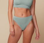Megan wearing the Cloud Cotton Highwaist Thong in Seaglass, featuring a flattering high-waisted fit with minimal back coverage, designed for all-day comfort. sizing: Megan wears a size Medium