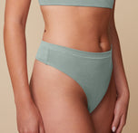 Close-up of Megan wearing the Cloud Cotton Highwaist Thong in Seaglass, emphasizing the soft, breathable cotton fabric and high-rise waistband.