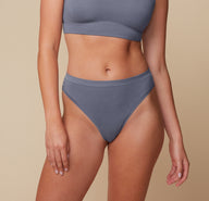 Front view of Megan in the Cloud Cotton Highwaist Thong in Slate. The high-rise waistband and soft V-front silhouette offer breathable coverage with a barely-there feel. sizing: Megan wears size Medium