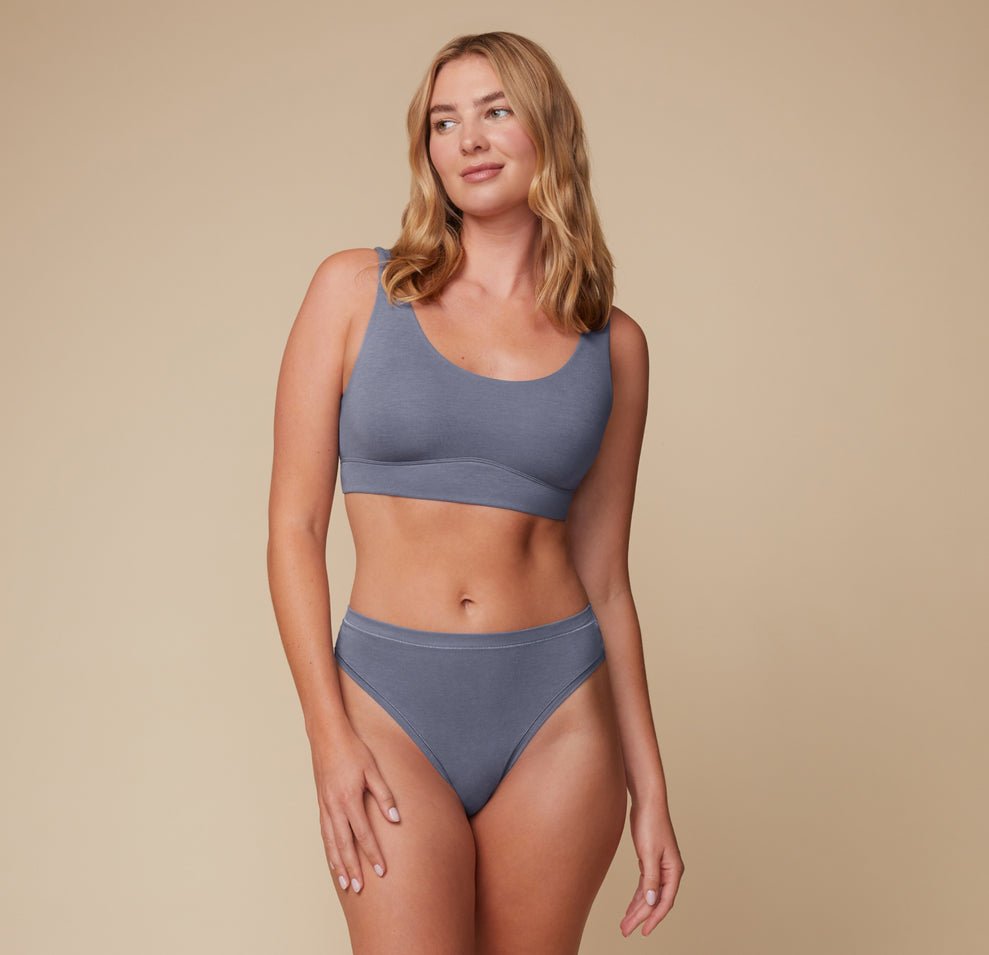 Full-body shot of Megan in the Cloud Cotton Highwaist Thong and matching Cloud Cotton Scoop Bralette in Slate. The lounge-ready set offers effortless comfort and soft support.