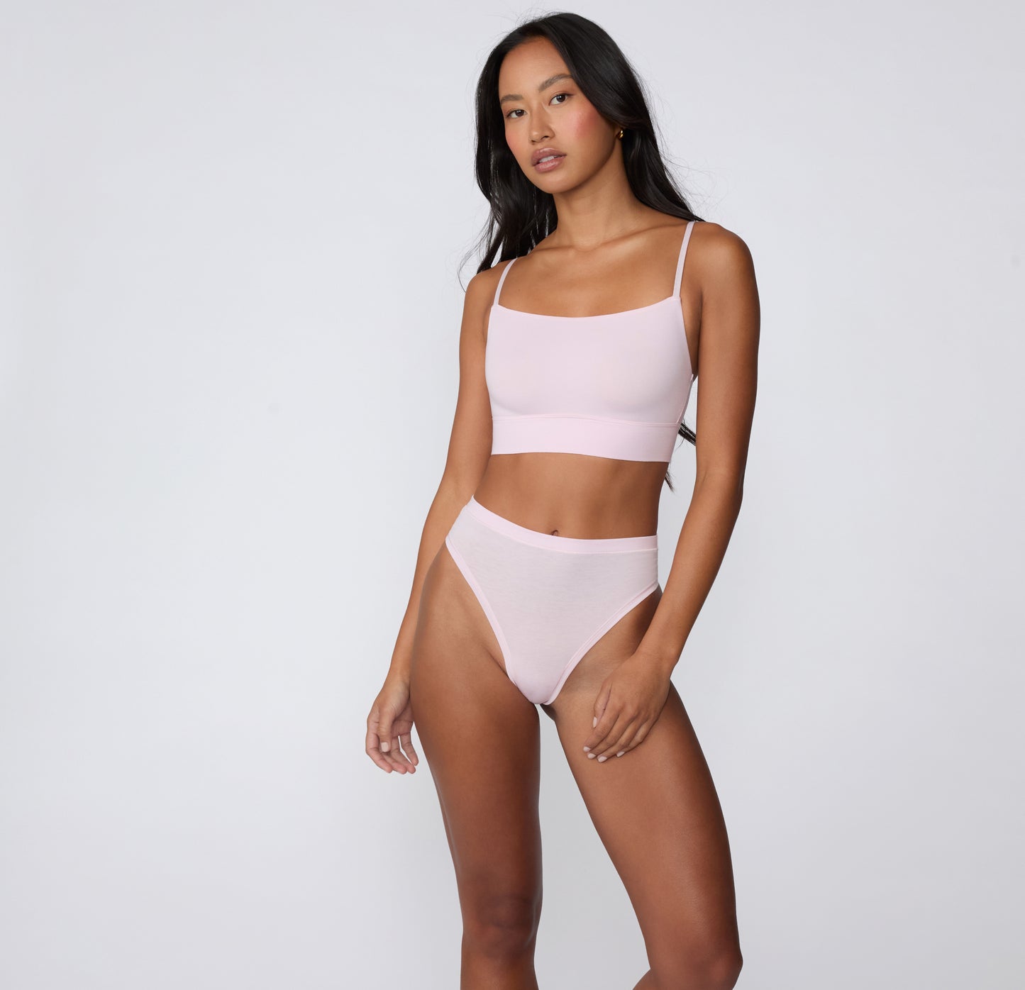 On a clean studio backdrop, a full-body view shows a model wearing the Cloud Cotton Highwaist Thong in Primrose with the matching Cloud Cotton Thin Strap Bralette, highlighting the high-rise waistband and soft cotton modal fabric.