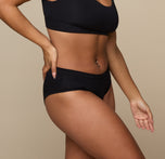 Three quarter angle of Jade in the Cloud Cotton Hiphugger in Black. The comfortable leg openings and minimal seams are emphasized.